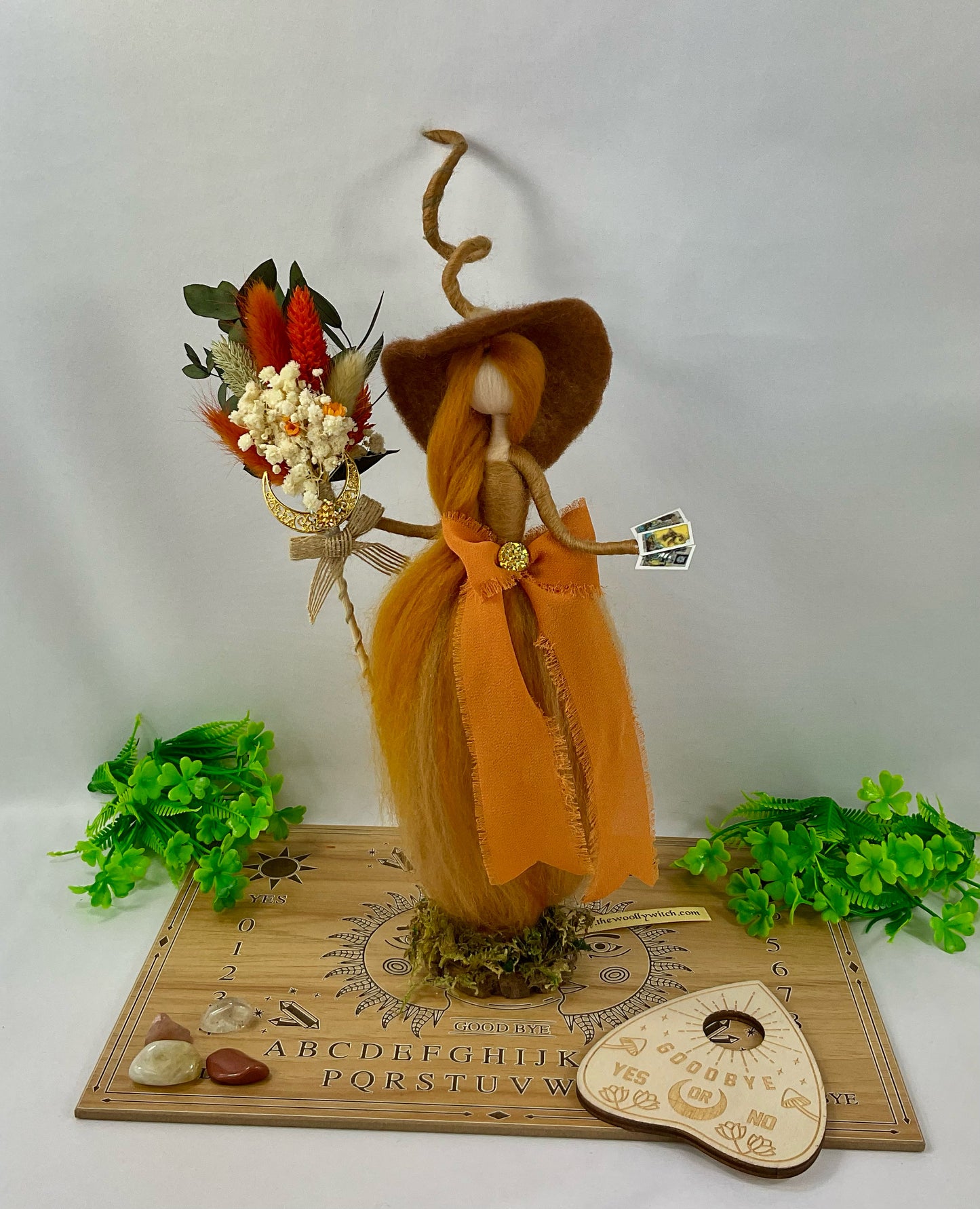 Orange witch with ouija board display and tumble stones