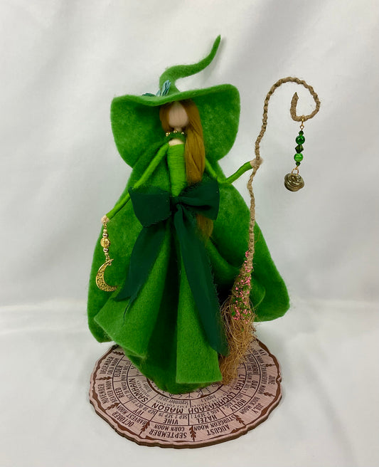 Green witch with a floppy hat and cape